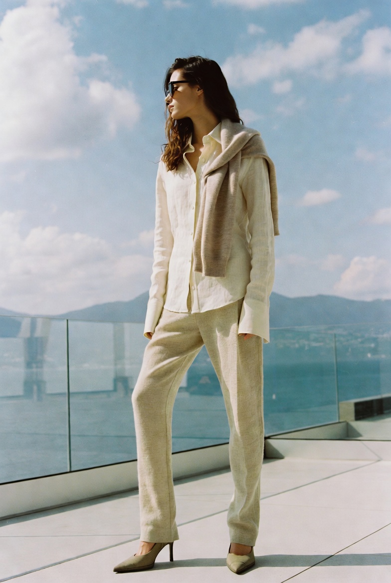 A woman in slim straight-leg linen trousers and a shirt at Lake Como, ESVRA Power of Linen edit