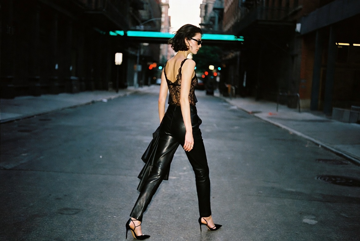 Lingerie as outerwear — a black lace camisole worn with leather trousers in SoHo at dusk, ESVRA