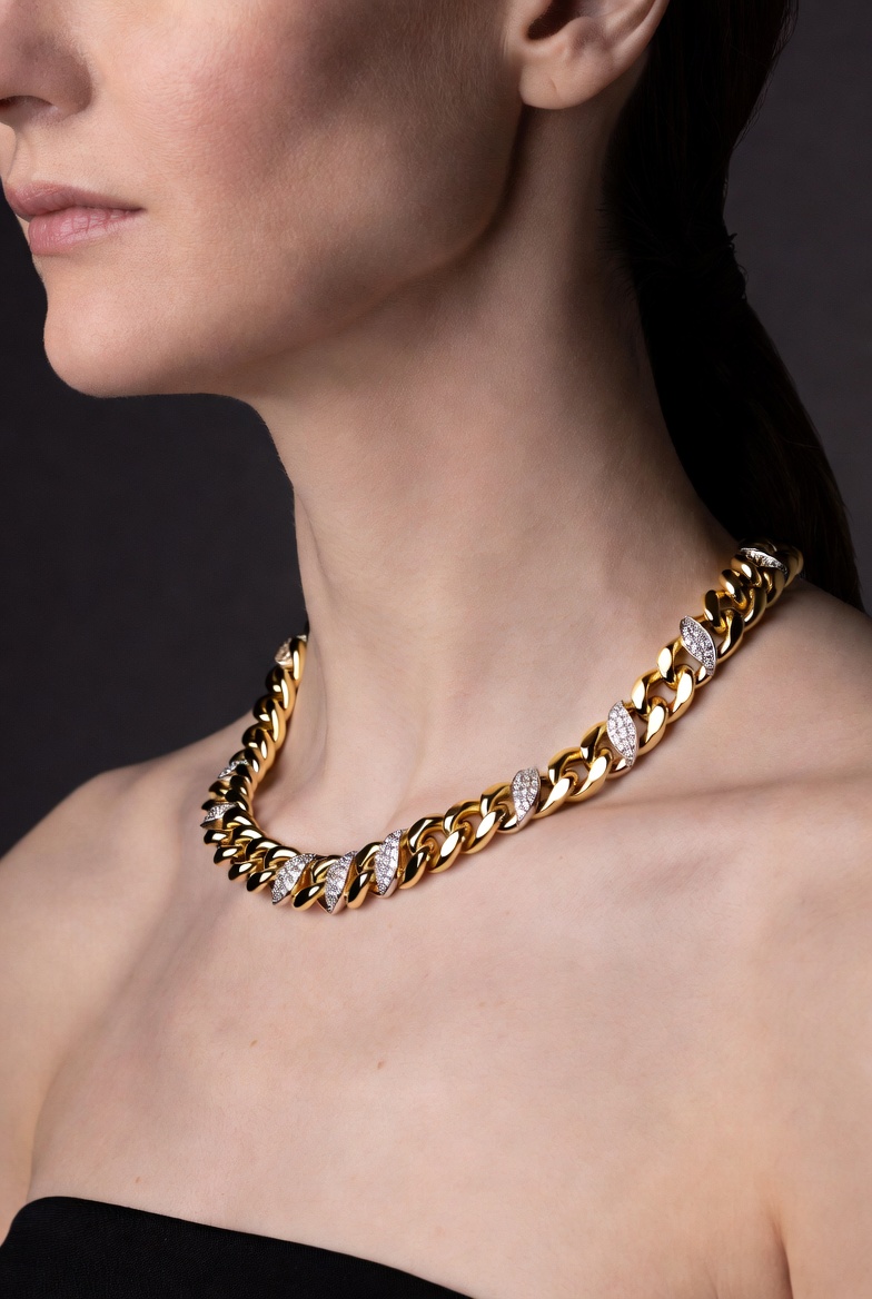 A model wearing a bold gold chain necklace