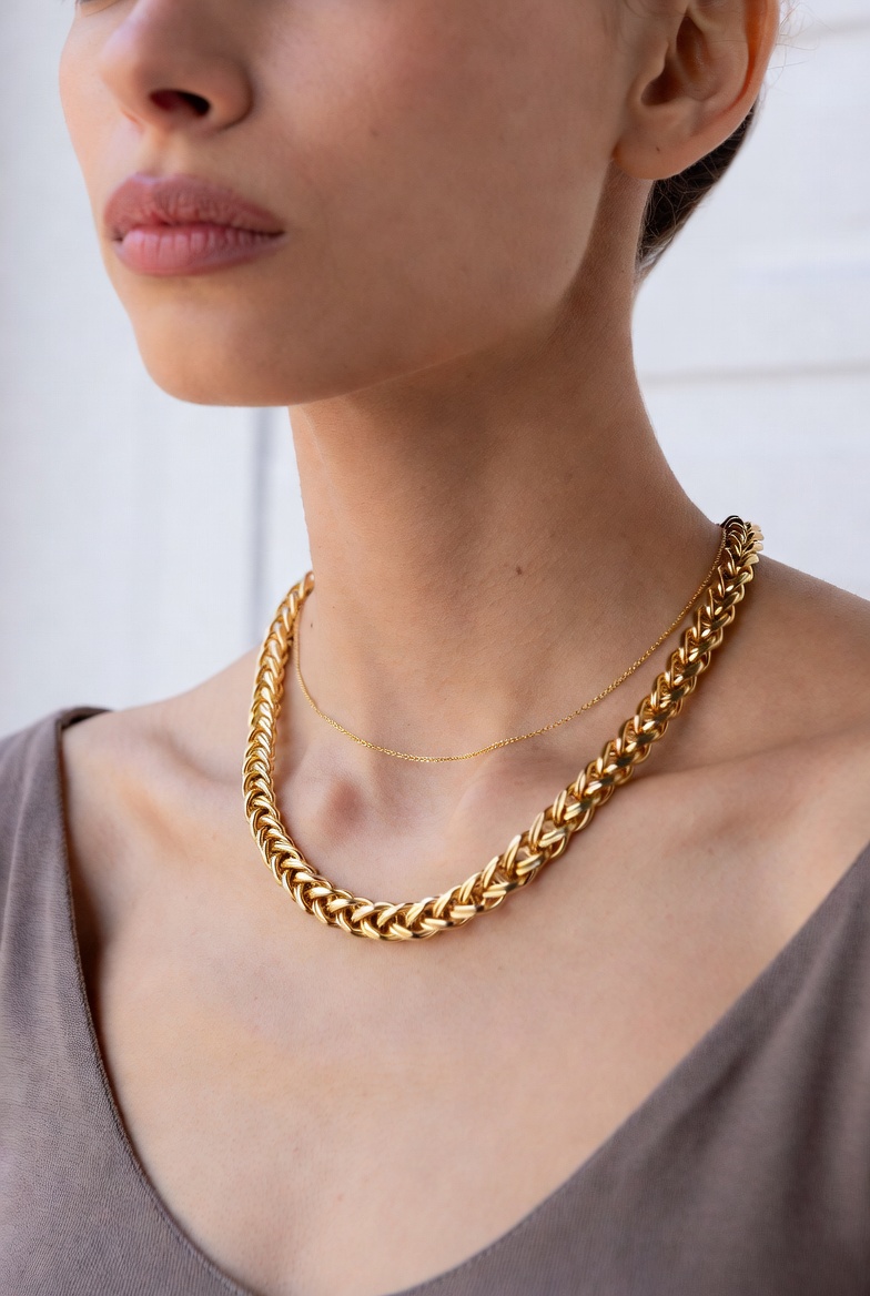 A model wearing a gold medallion necklace